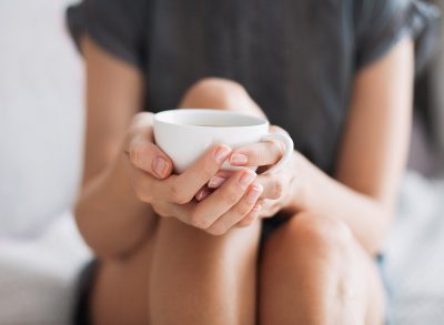 woman drinking tea in white cup