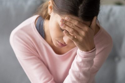 woman dealing with severe headache or migraine at home