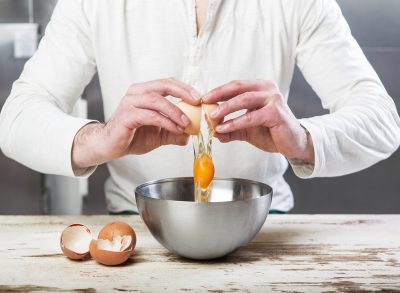 Man cracking egg into bowl