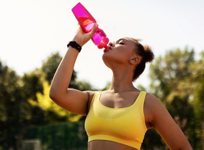 Woman drinkinig water outside