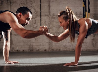 fit couple doing couples workout in gym