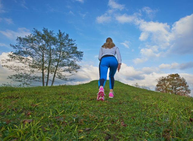 Woman doing uphill walking training to lose belly fat fast