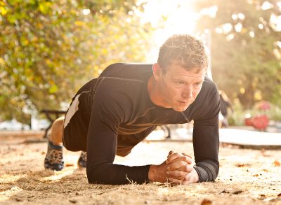 man exercising in park, doing plank