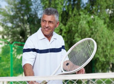 mature man playing tennis, exercises to prevent osteoporosis in your 50s