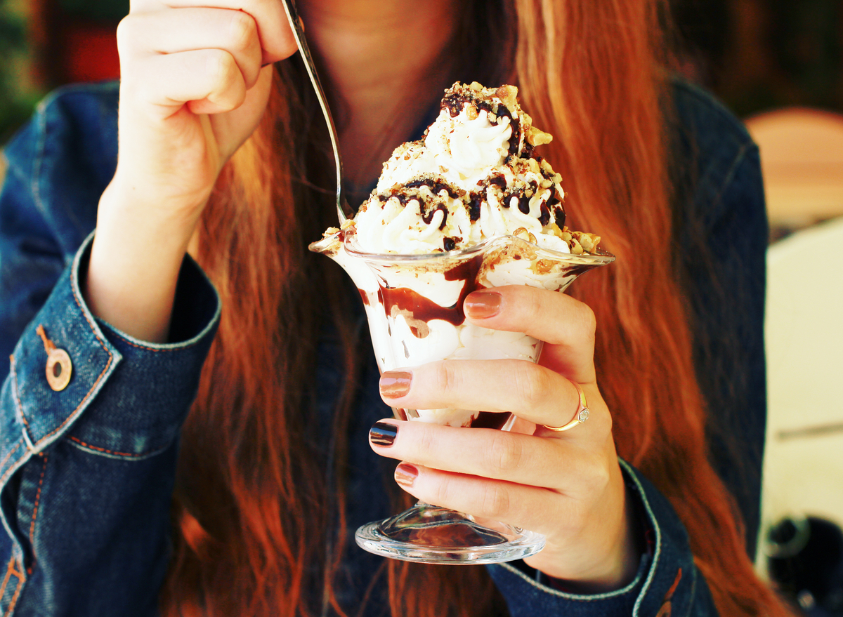 https://www.eatthis.com/wp-content/uploads/sites/4/2022/06/woman-eating-ice-cream-sundae.jpg?quality=82&strip=1