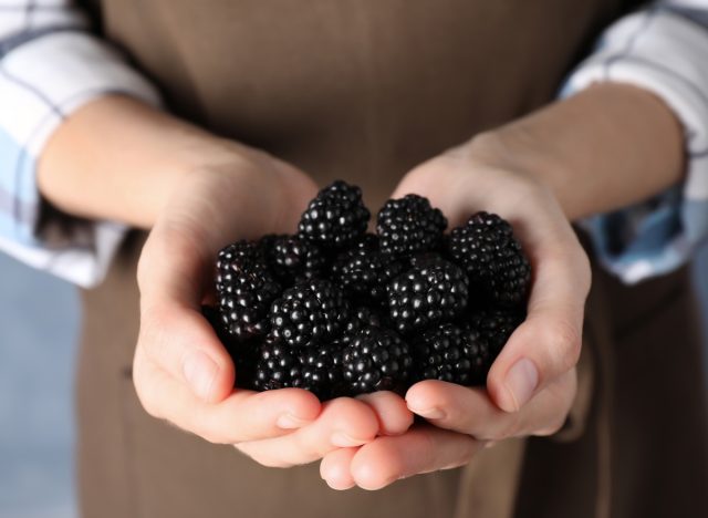 woman holding blackberries