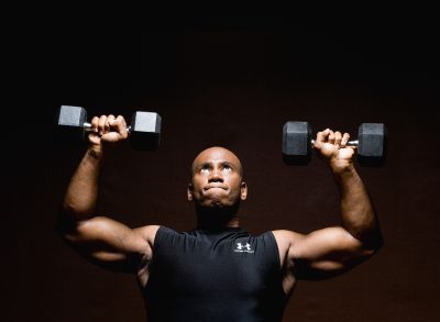 man performing dumbbell exercise to get rid of love handles for good