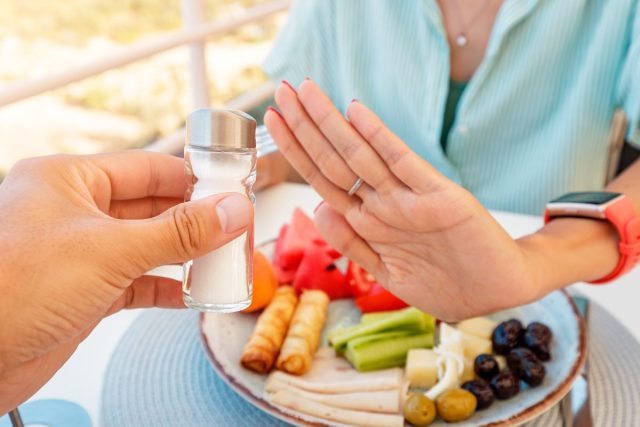 woman refusing salt shaker