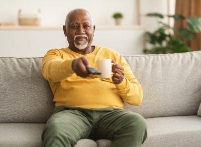 mature man sedentary at 60 on the couch watching tv