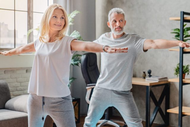 older couple doing yoga, demonstrating the strength training habits that slow aging