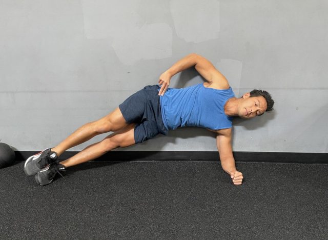 Trainer demonstrating side plank hip raises to restore muscle mass after age 50