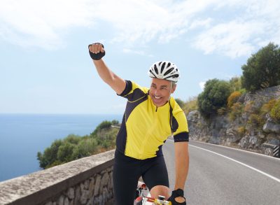 happy mature man demonstrating the cycling habits that slow aging