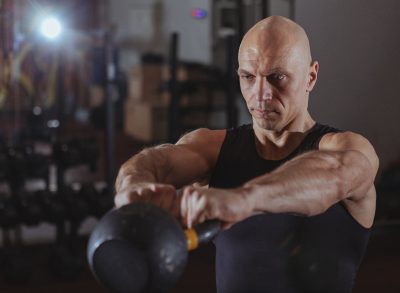 man demonstrating kettlebell workout to get rid of a big belly and slow aging