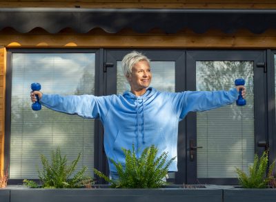 woman lifting dumbbells part of visceral fat reducer at 60 workout