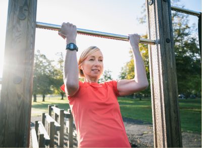 mature woman performing pull-up bar exercise tricks to slow down aging