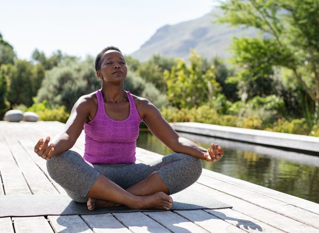 mature woman doing yoga, meditation, yoga habits that slow aging