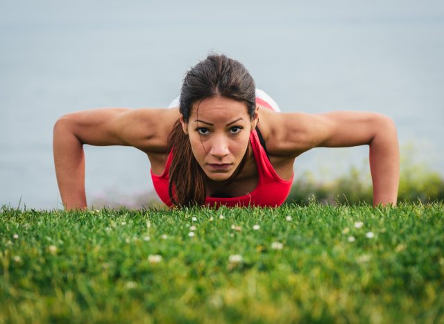 woman performing pushups in the grass demonstrating how to get rid of your bra bulge