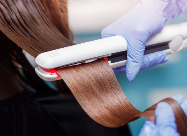 close-up woman receiving hair straightening keratin treatment