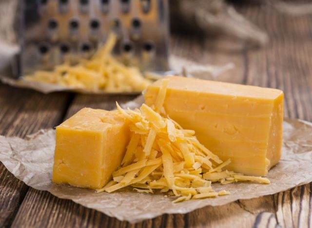 block of cheddar cheese and grated cheddar cheese