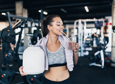 woman drinking protein shake when working out