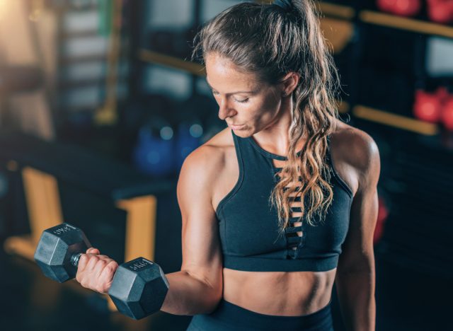 woman demonstrates how to gain muscle mass with dumbbell exercises at gym