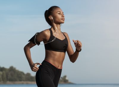 fit woman running on beach, demonstrating exercise after eating