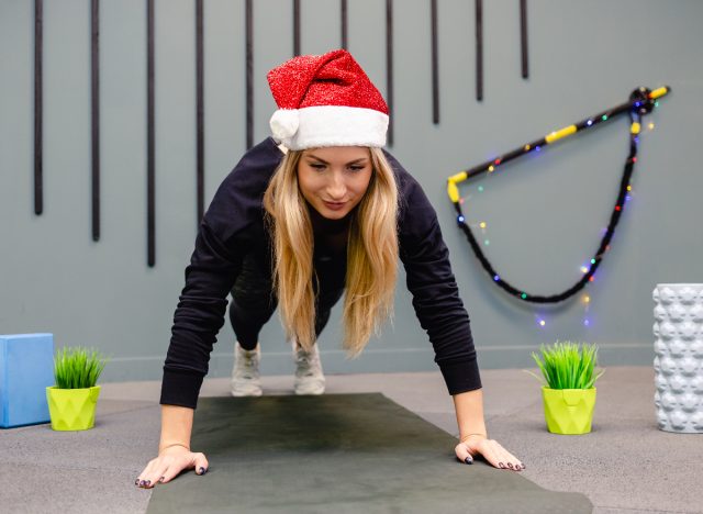 woman dressed in santa hat doing christmas workout, easy fitness habits during holidays