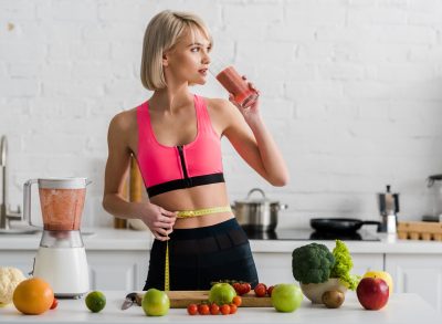 woman dieting for weight loss concept, drinking smoothie in kitchen