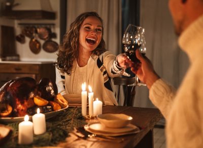 happy couple clinking glasses at dinner table, concept of creative date night ideas at home