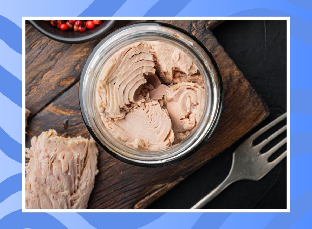 can of tuna on a wooden table on a blue background