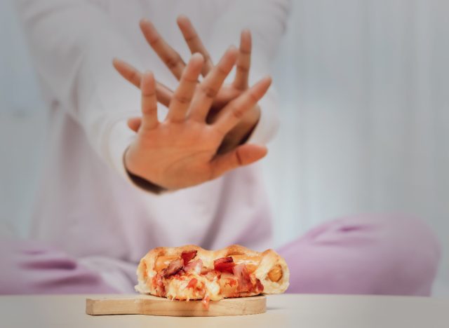 woman saying no to pizza, late-night foods