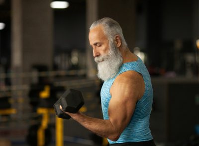 mature muscular man lifting weights, concept of exercise habits that destroy arms after 50