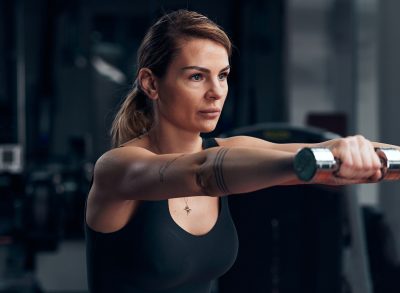 fit woman demonstrating lightweight dumbbell exercises