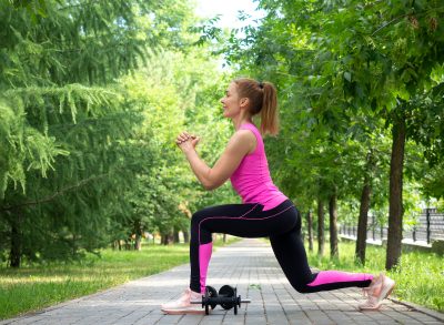 woman doing outdoor lunges, concept of compound exercises to change your body shape