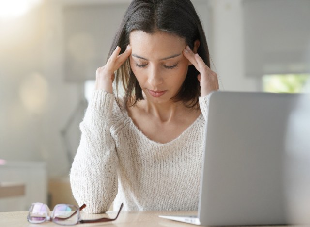 woman stressed at desk with laptop