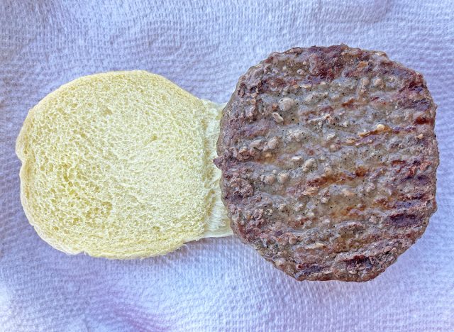 A previously frozen Kirkland Signature grass-fed beef patty, fresh off the grill and served on a bun