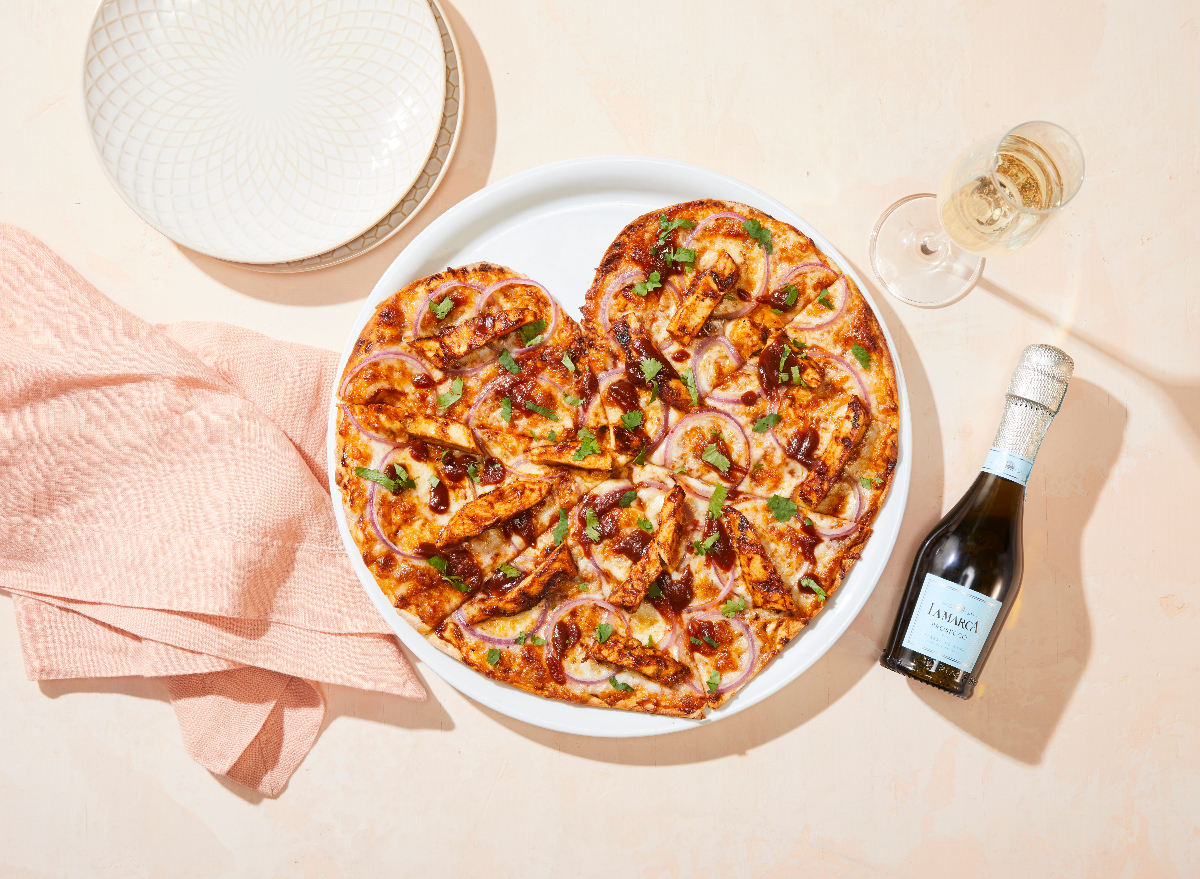 https://www.eatthis.com/wp-content/uploads/sites/4/2023/05/california-pizza-kitchen-mothers-day-heart-shaped-pizza-prosecco.jpg?quality=82&strip=all