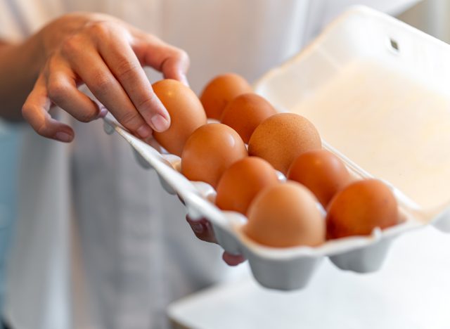 carton of eggs with a hand reaching for an egg