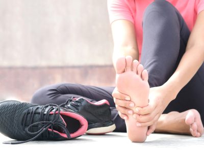 woman holding foot, foot pain, concept of habits that destroy your feet