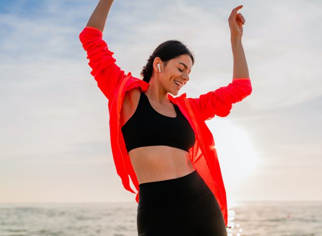 Plajda dans eden mutlu fitness kadını, iyi yaşlanmak için günlük alışkanlıklar kavramı