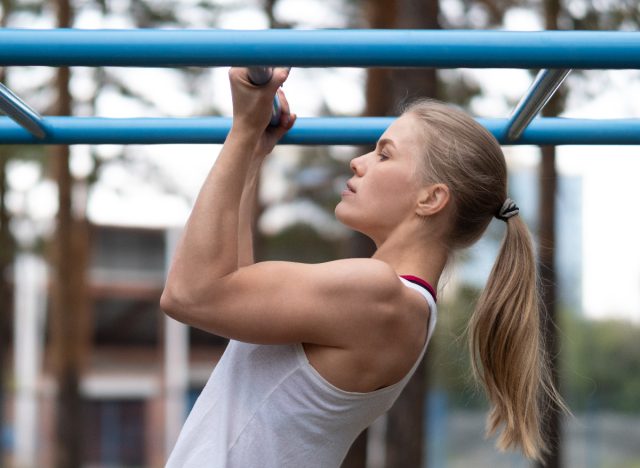 fitness woman doing chin-ups, concept of the best belly fat exercises for your 30s