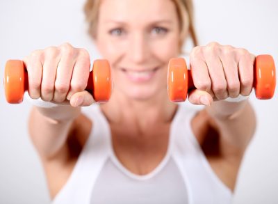 woman doing dumbbell arm exercises, concept of least effective exercises for underarm fat