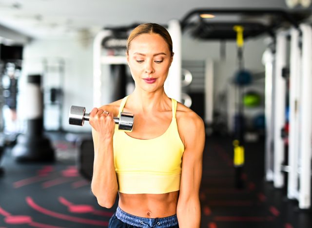 fit woman doing bicep curls demonstrating strength exercises for arm cellulite