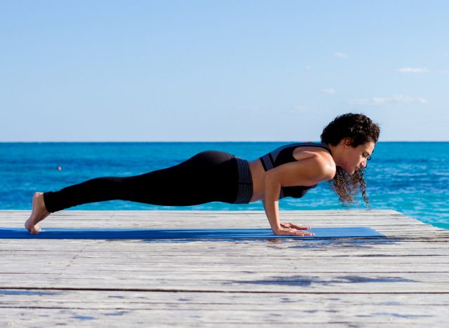 woman doing Chaturanga, concept of yoga exercises to reduce arm fat