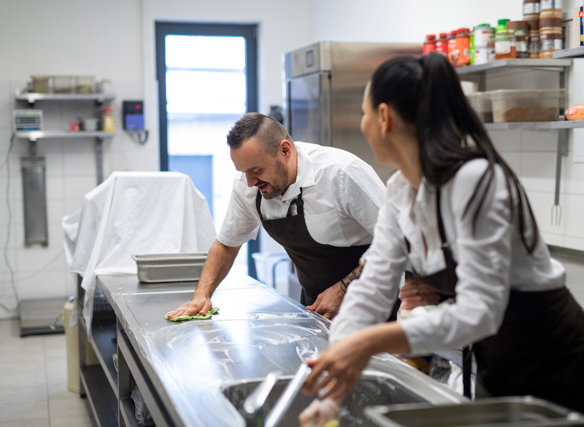 chef and cook cleaning restaurant kitchen