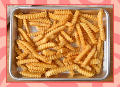 crinkle cut frozen french fries on a sheet tray fresh out of the oven