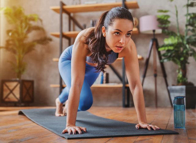 woman doing mountain climbers, concept of workouts to lose belly fat