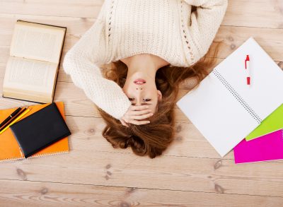 woman stressed on floor, concept of ways stress can cause weight gain