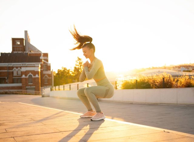 fit woman doing jump squats outdoors, concept of best workouts to burn calories and fat