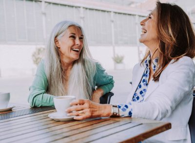 mature friends enjoying coffee at cafe